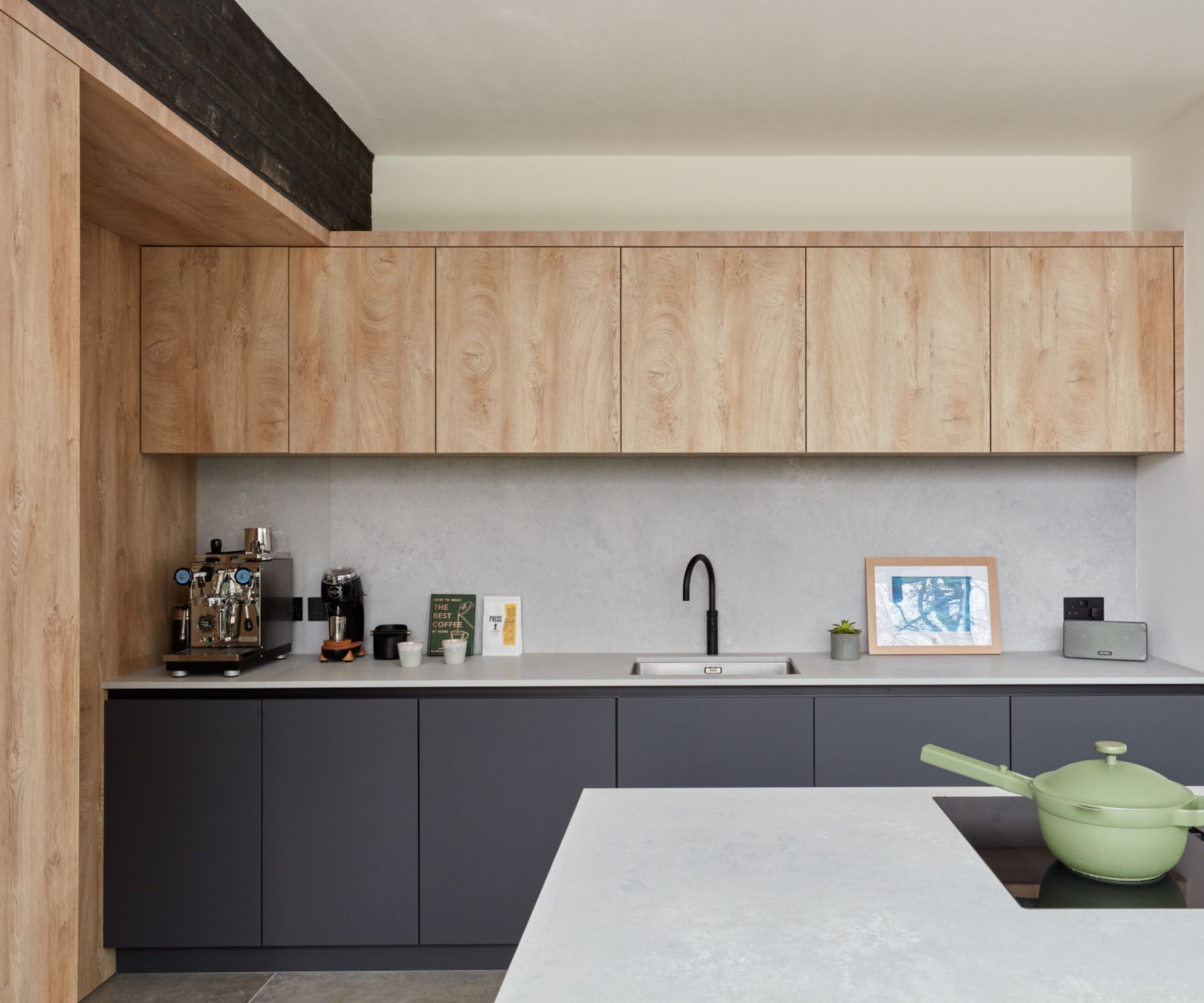 A large kitchen with wood and dark blue cabinets and concrete countertops