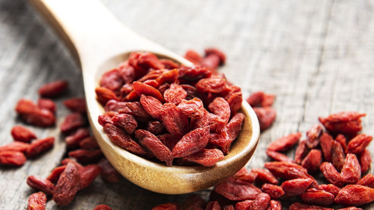 Dried goji berries on wooden spoon