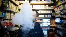 A person vapes at a smoke shop in New York City.