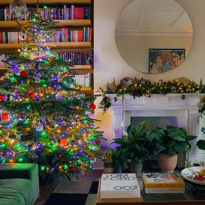lit christmas tree and garland over a fireplace