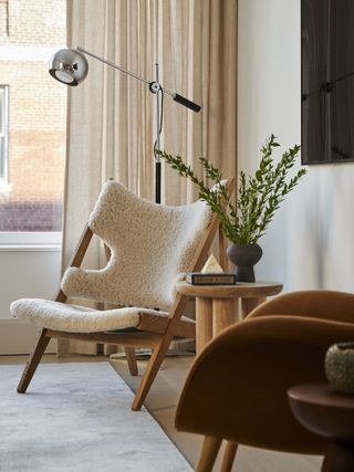 sheepskin chair and rust velvet chair with minimalist floor lamp