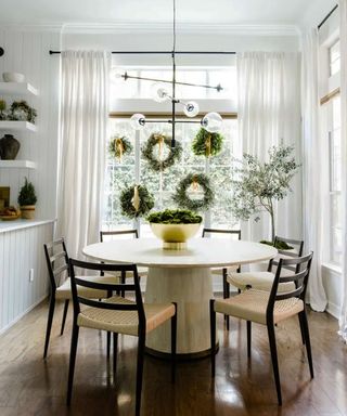 Scand-inspired dining room with christmas wreaths in window
