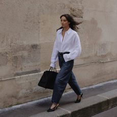 fashion influencer @modadamour wearing a white button-down shirt with barrel jeans