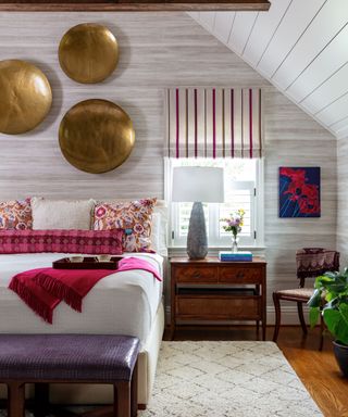 bohemian bedroom with gold wall decor, striped curtains and pink soft furnishings