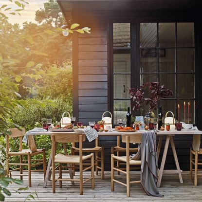 Decorated dining table and chairs on patio area outside of house