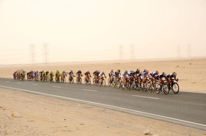 The peloton single file in the winds of stage 1 of the Ladies Tour of Qatar