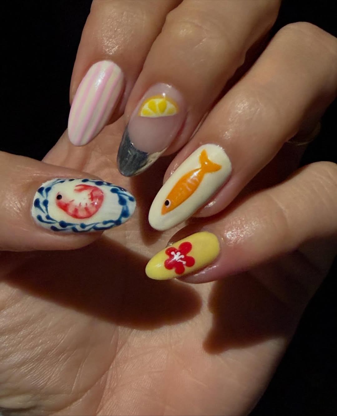 a person wearing a manicure with fish designs