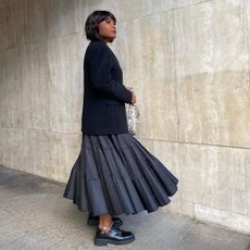 @frannfyne wears loafers and a midi skirt