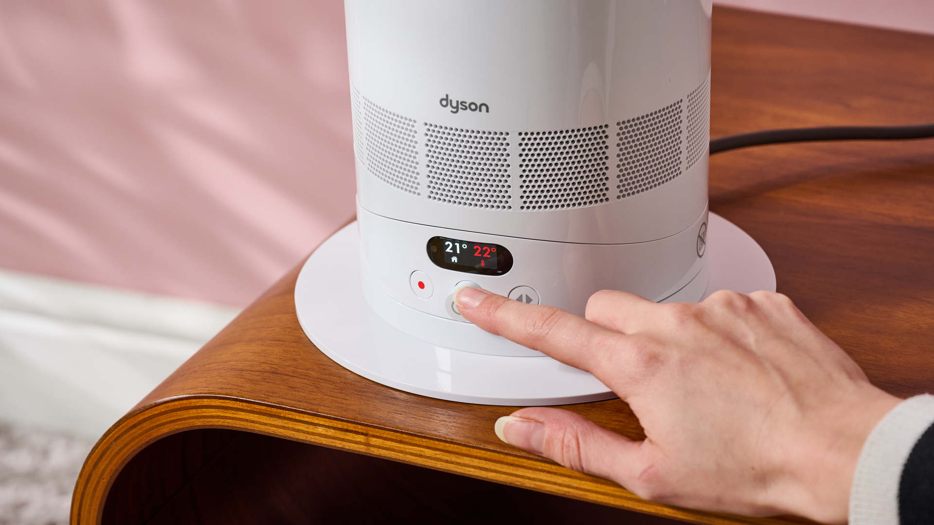 Someone is using the dial to adjust the temperature of the Dyson Hot and Cool HF1.