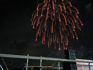 A firework explodes in red at a race track.