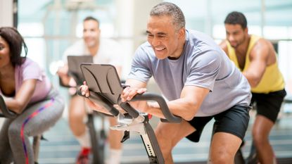 Men and women in a spin class exercising over 50
