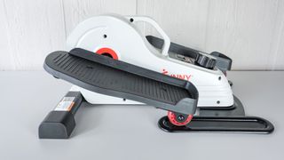 The Sunny Health & Fitness Under Desk Elliptical unboxed and on a table