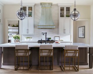 Modern luxe kitchen scheme with extended, neutral splashback, orb pendant lights and sophisticated bar stools