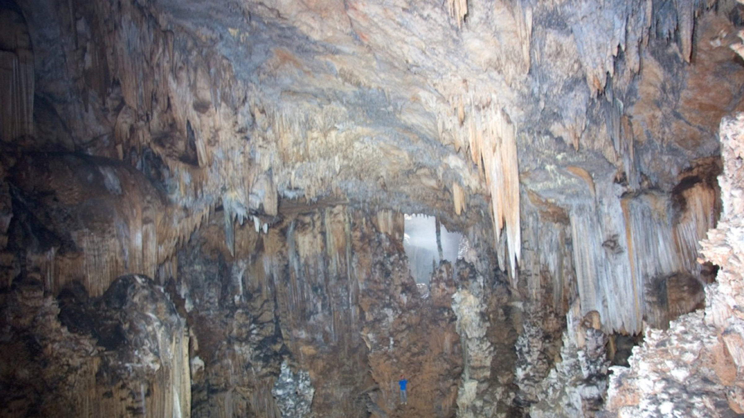 L'intérieur de la grotte de la terreur de minuit au Belize, avec une personne en bleu pour l'échelle.