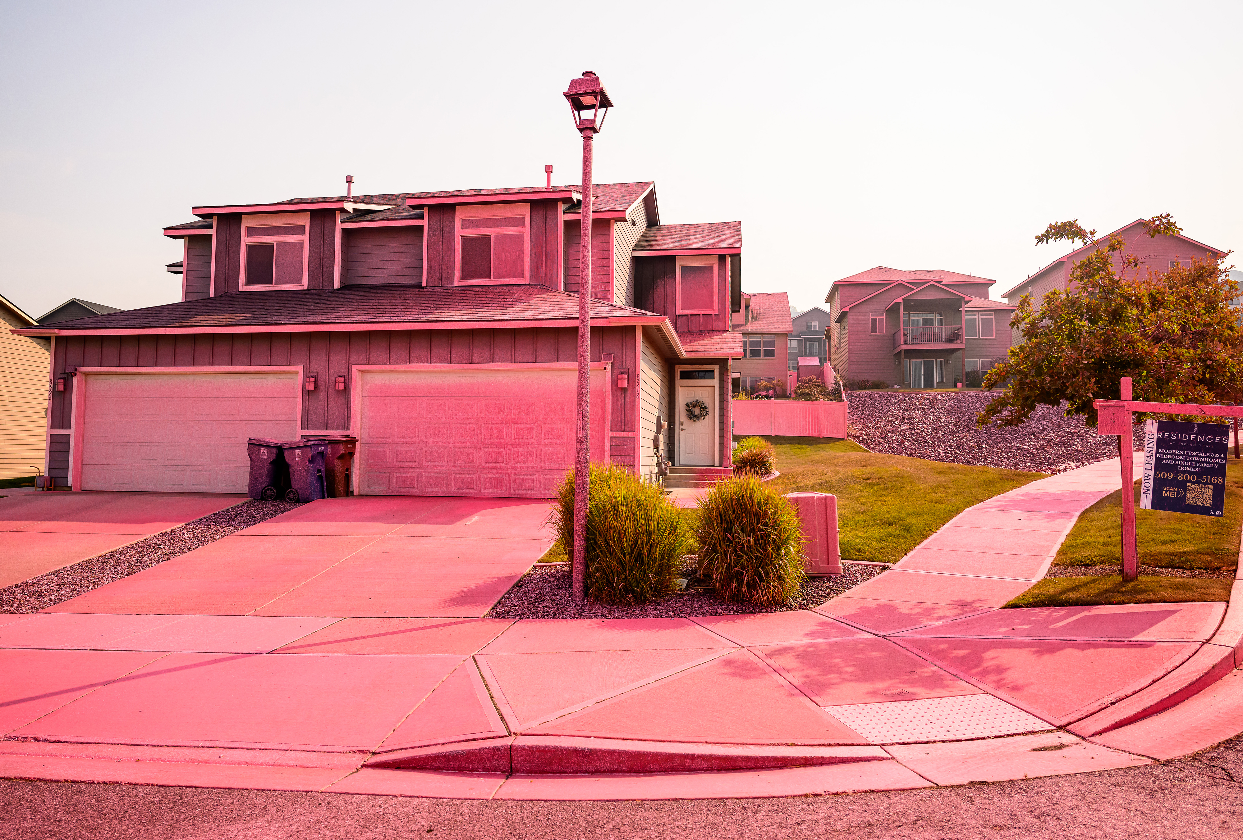 TOPSHOT - A home is covered in fire retardant dropped by firefighters during the Old Trails Fire in Spokane, Washington, on August 4, 2026. US authorities arrested a man on August 3, 2026 on suspicion of arson in connection with the biggest of three fires burning around the northwestern city of Spokane, as firefighters raced to contain flames that have displaced tens of thousands. Wildfires supercharged by drought and intense heat have torn through the city in Washington state, burning thousands of acres and reducing hundreds of buildings to cinders while anxious families await news on when they can return. (Photo by Josh Edelson / AFP via Getty Images)