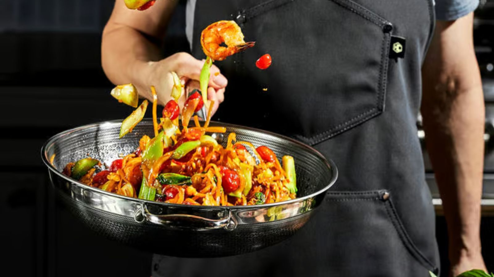 Tossing a shrimp and vegetable stir fry in a HexClad wok 