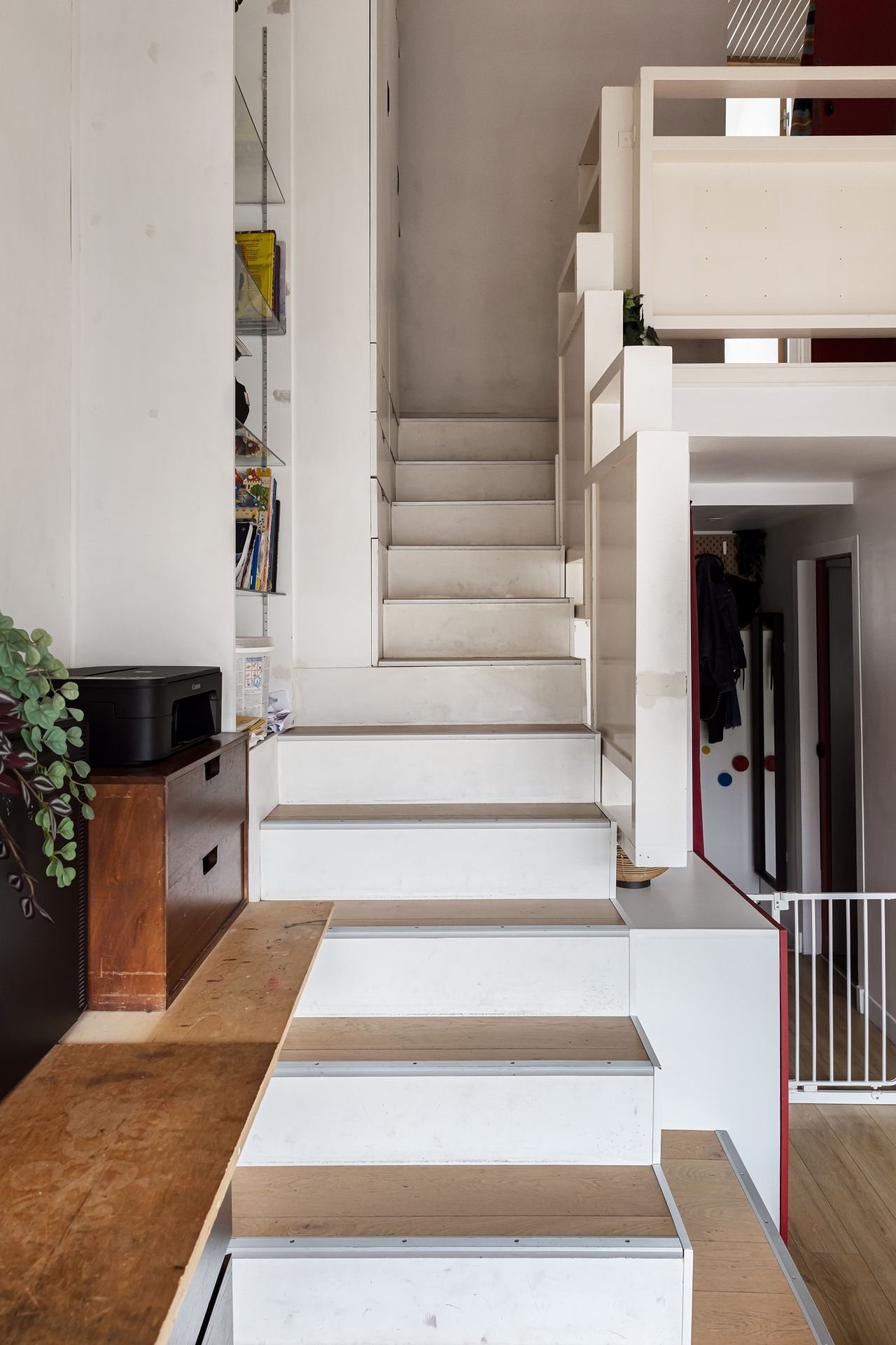 A sculptural staircase links the three levels of the apartment