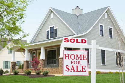 House with a home for sale and sold sign