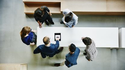 Aerial view of a group of advisers with a client gathered around a table.