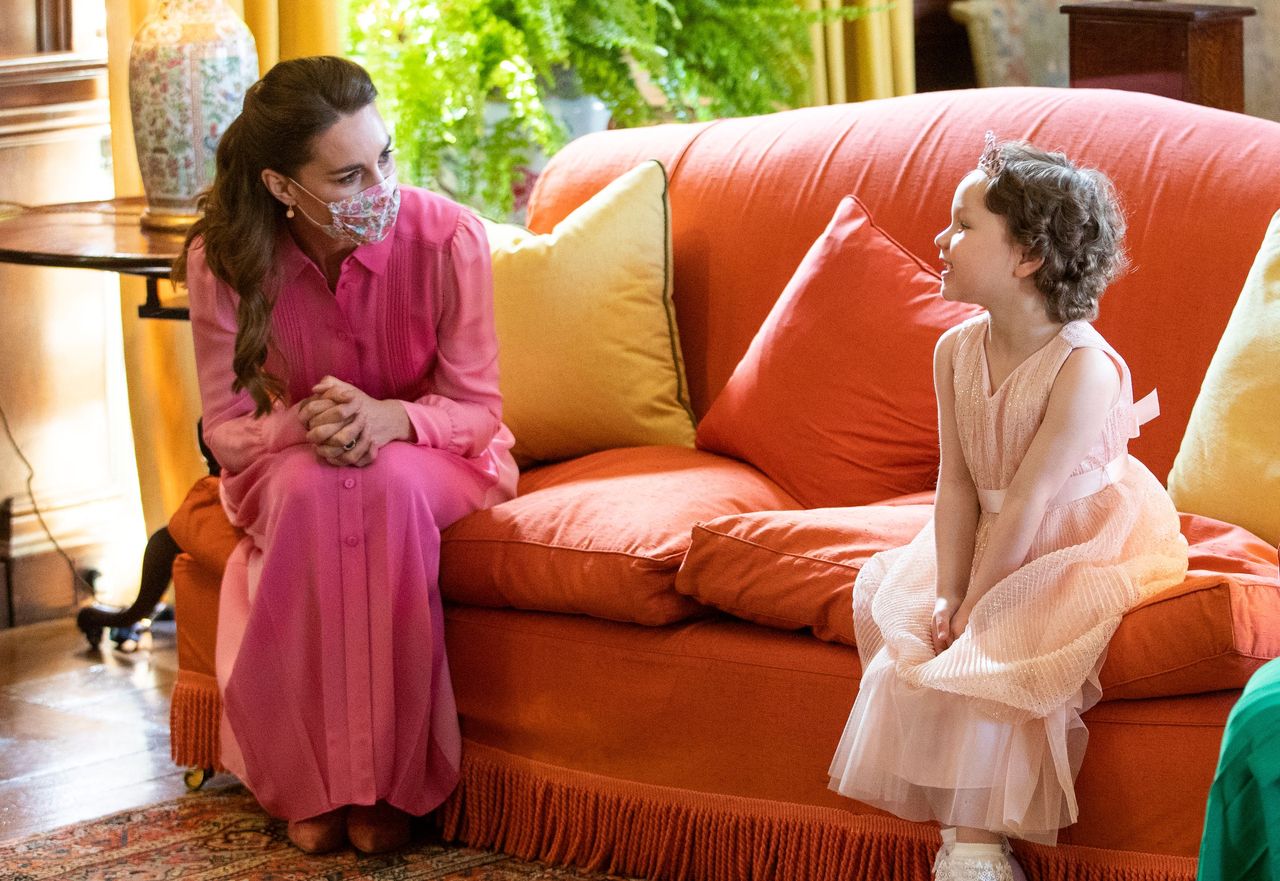 Britain's Catherine, Duchess of Cambridge (L) meets five year-old Mila Sneddon, a cancer patient who featured in an image from the Hold Still photography project which showed her kissing her father Scott through a window whilst she was shielding during her chemotherapy treatment, at the Palace of Holyroodhouse in Edinburgh, Scotland on May 27, 2021