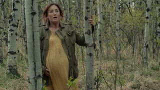 Anna (Ashley Johnson) heavily pregnant in a yellow dress and overcoat in The Last Of Us