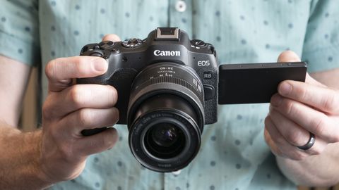 Canon EOS R8 in the hand with vari-angle screen flipped out