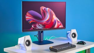 Alienware AW2725D on a desk against a blue background