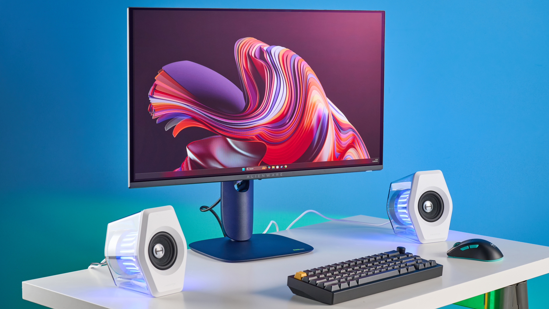 Alienware AW2725D on a desk against a blue background