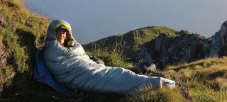 Man in Rab Mythic 400 sleeping bag in the mountains