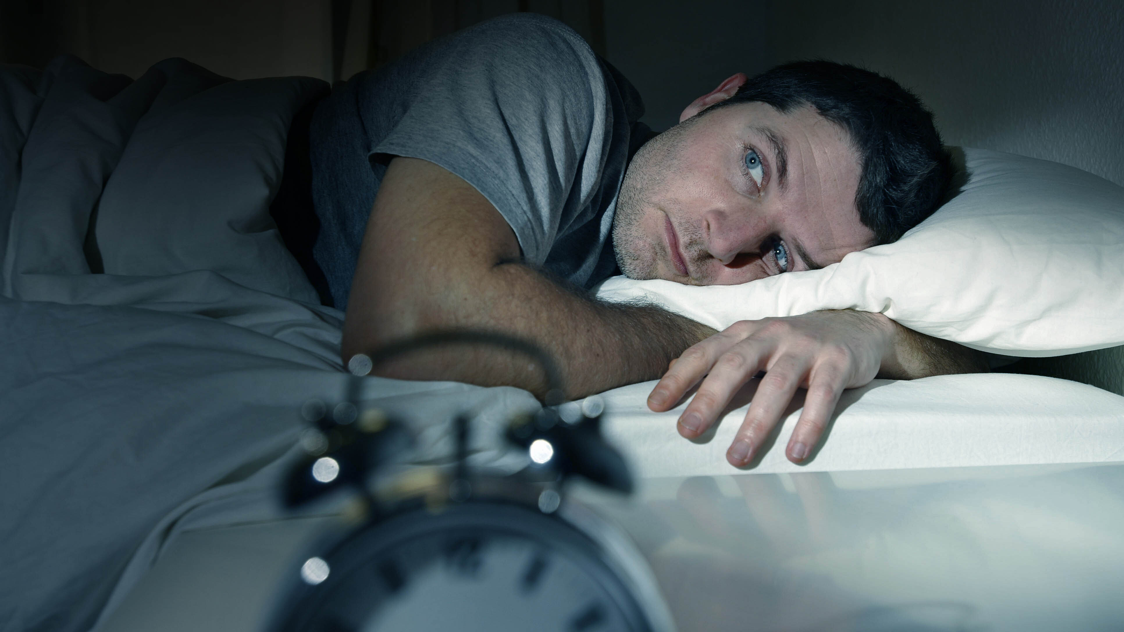 Man in bed unable to get to sleep