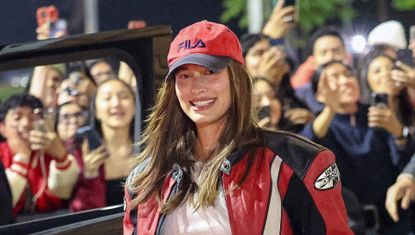 Hailey Bieber wearing a red baseball cap