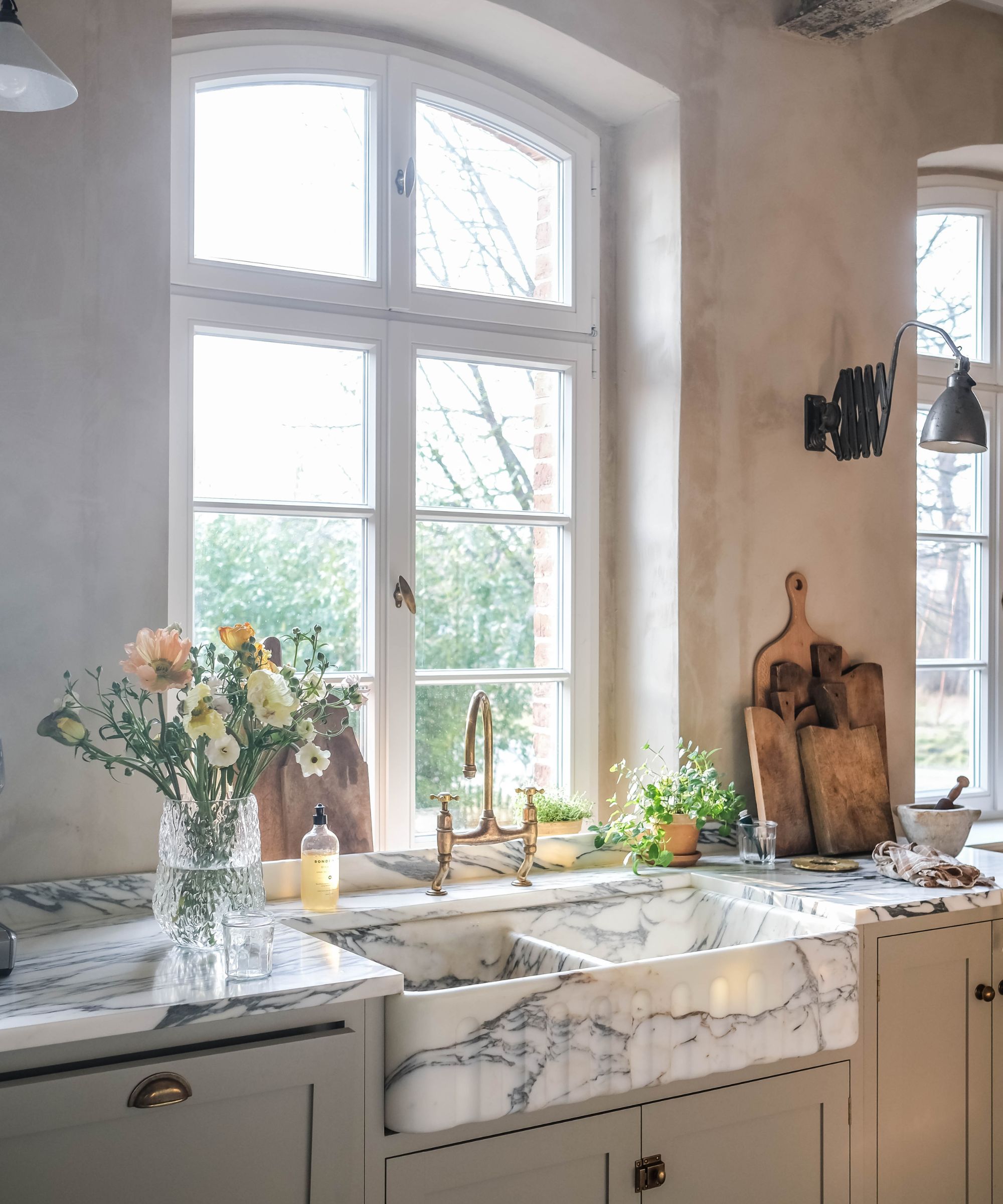 A warm neutral kitchen with taupe cabinets and a marble sink