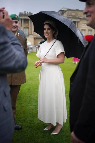Princess Eugenie wears a white dress with metallic pumps to a royal garden party