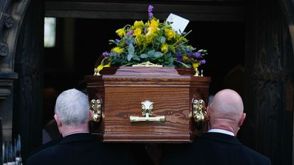 A coffin carried by men