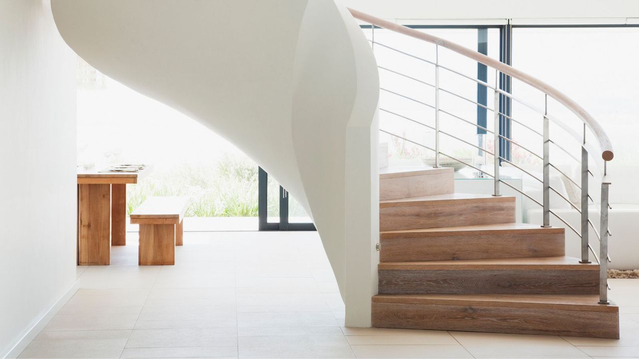 A large white winding staircase in a minimalist room