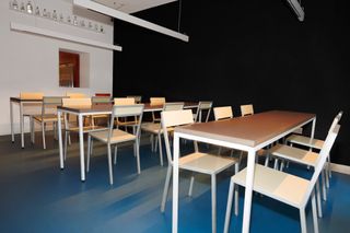 utilitarian tables and chairs in pared-back space