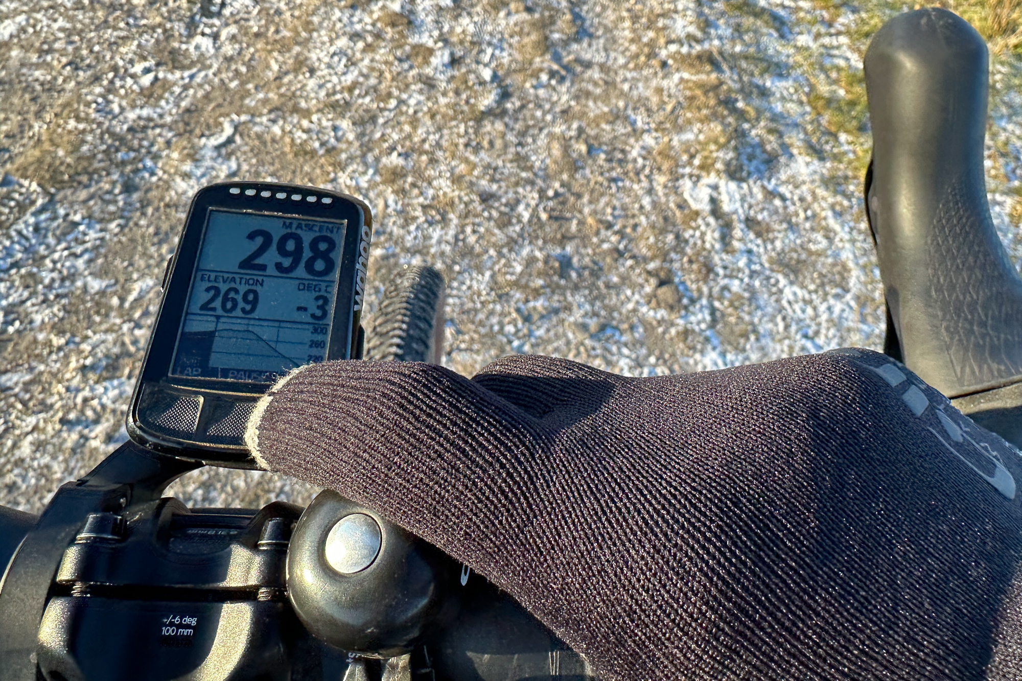 close up of a man wearing black gloves operating a bike computer