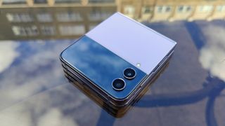 Samsung Galaxy Z Flip 4 review: phone folded up on a table with reflections of clouds
