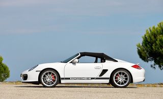 White sports car with soft top and "Porsche" written along the side