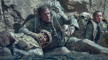 Three US Army personnel taking cover in Netflix's War Machine movie