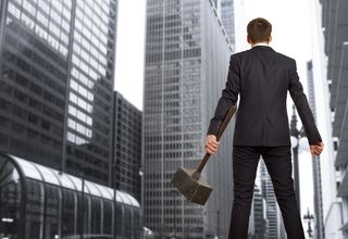 An angry man holds a sledge hammer.