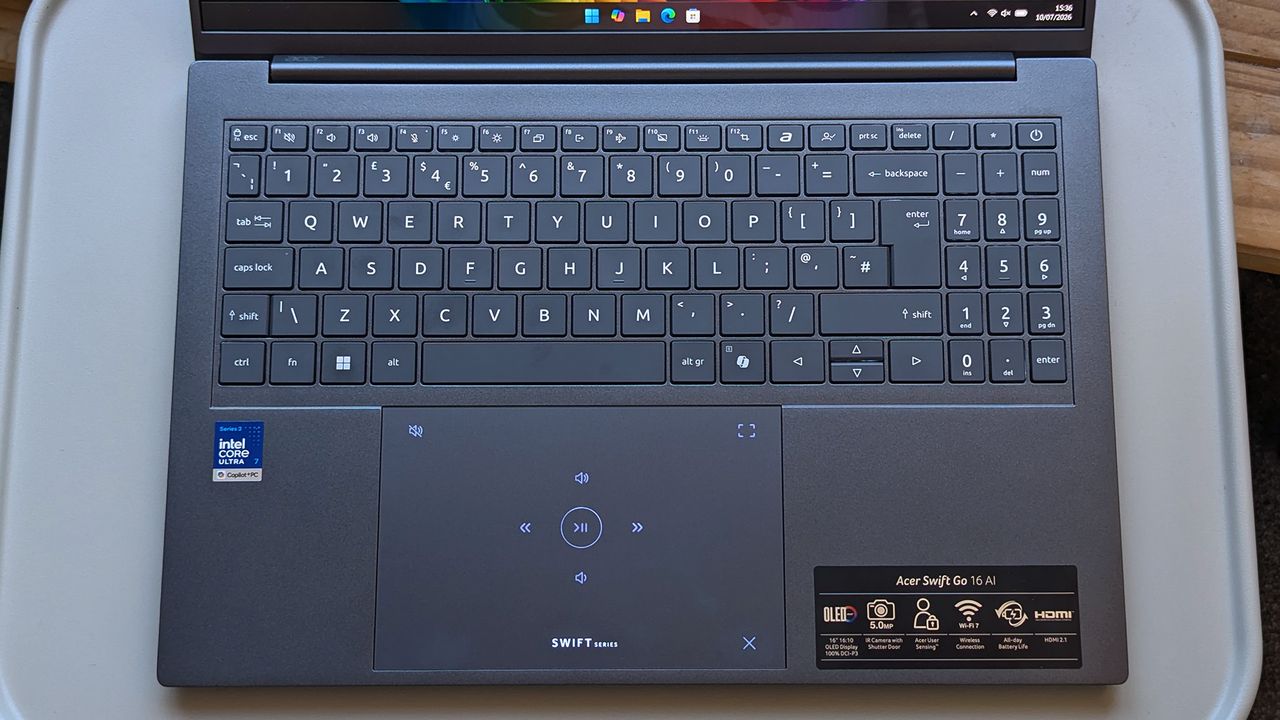 A close-up of the Acer Swift Go 16 AI keyboard and touchpad, featuring illuminated media‑control icons.