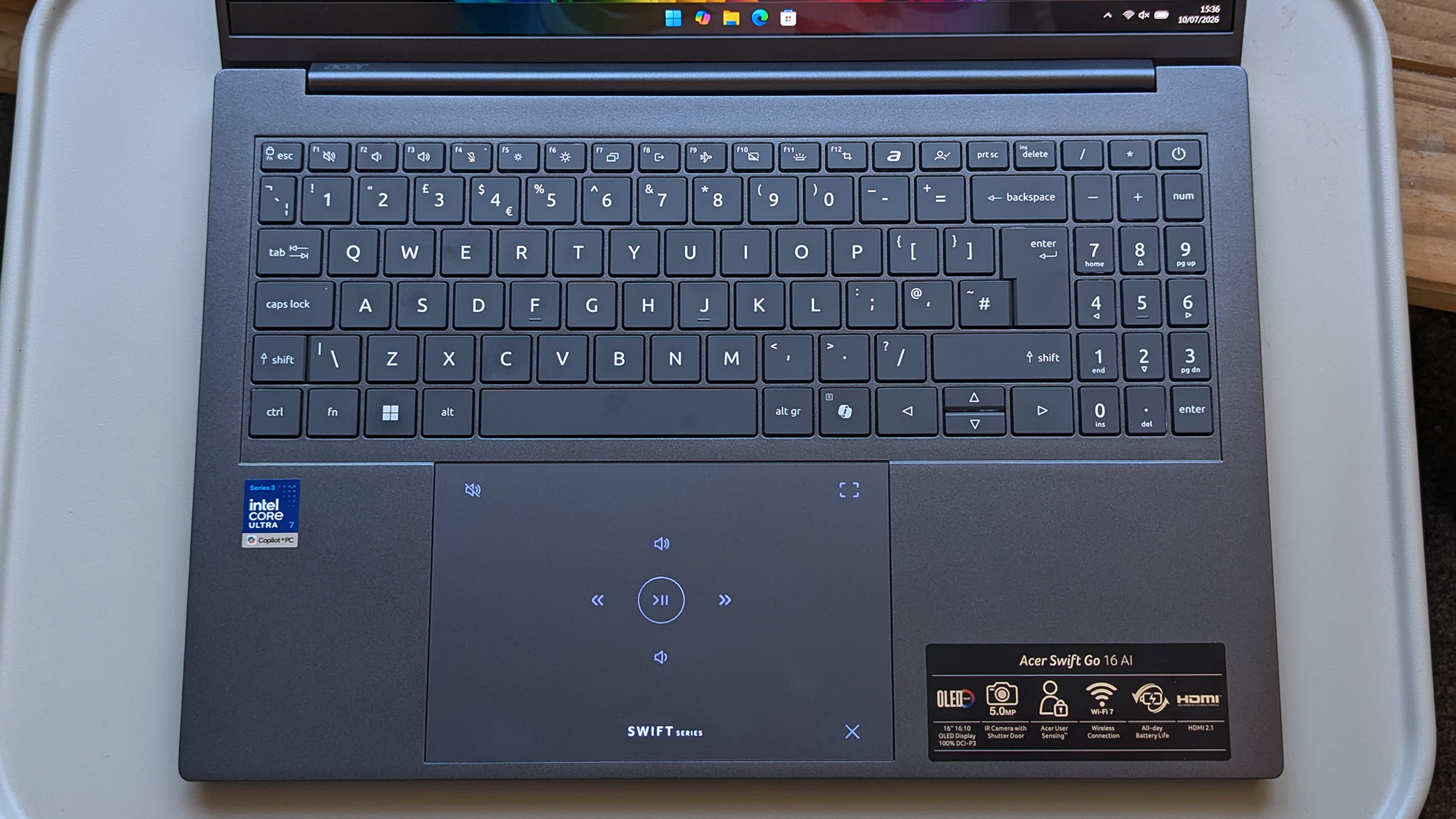 A close-up of the Acer Swift Go 16 AI keyboard and touchpad, featuring illuminated media‑control icons.