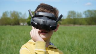 DJI Goggles 3 worn by a boy in a field