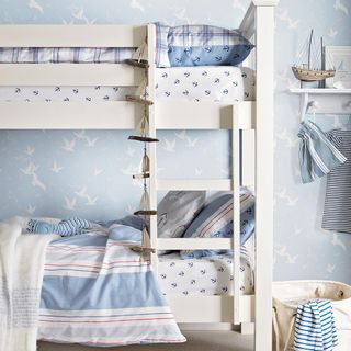 kids room with white bunk bed and blue patterned wallpaper