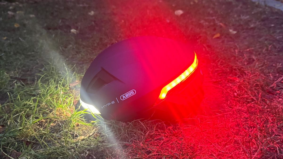 The Abus Hyp-E helmet with front and rear lights turned on