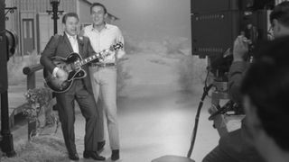 Roy Clark (1933-2018), playing a Gibson Byrdland guitar, and American country music singer and television host Jimmy Dean (1928-2010) on the set of 'The Jimmy Dean Show' at ABC Studio One in New York City, New York, 13th May 1965.