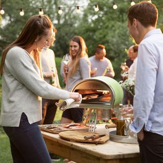 people with portable wood oven and lighting