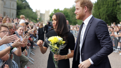 Meghan Duchess of Sussex and Prince Harry, Duke of Sussex speak with well-wishers at Windsor Castle on September 10, 2022 in Windsor, England. Crowds have gathered and tributes left at the gates of Windsor Castle to Queen Elizabeth II, who died at Balmoral Castle on 8 September, 2022.