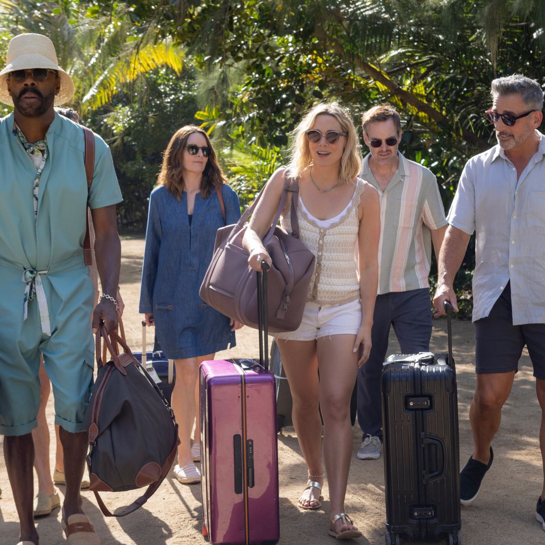 A group of adults (L to R - Colman Domingo as Danny, Tina Fey as Kate, Erika Henningsen as Ginny, Will Forte as Jack, and Steve Carell as Nick) wheel their luggage down a tropical path, in Episode 103 of The Four Seasons.